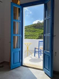 uma porta aberta com vista para uma mesa e cadeira em Villa Keroula em Alinda