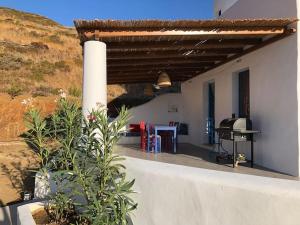 a white building with a roof with a grill at Villa Keroula in Alinda