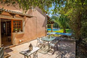 een terras met een tafel en stoelen voor een huis bij Villa Garrigo in Pollença