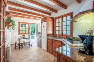 een keuken met houten kasten en een tafel met stoelen bij Villa Garrigo in Pollença