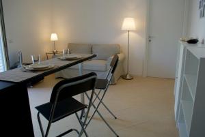 ヌマーナにあるBilo gianluca - nuovo appartamento in centro a Numanaのリビングルーム(テーブル、椅子、ソファ付)