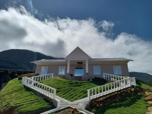 una casa en la cima de una colina con césped verde en Pousada & Hotel Fazenda Segredo Das Águas en Alto Caparao