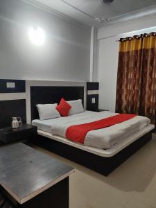 ein Schlafzimmer mit einem großen Bett mit einer roten Decke in der Unterkunft Hotel Parbhat Palace in Katra