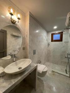 a bathroom with a sink and a toilet and a mirror at The Pilgrim Ephesus in Selçuk