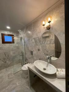 a bathroom with a sink and a toilet and a mirror at The Pilgrim Ephesus in Selçuk