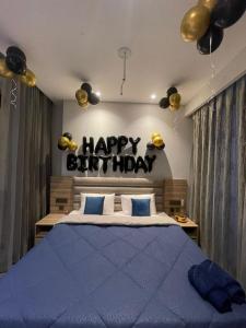 a bedroom with a happy birthday sign above a bed at Skystay in Greater Noida