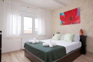 a bedroom with a large bed with a red flower painting on the wall at Centric apartment Gran Via 5 in Hospitalet de Llobregat