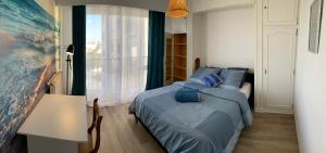 1 dormitorio con cama, mesa y ventana en 3 chambres avec vue dégagée au calme proche Paris et aéroport - parking en Le Bourget