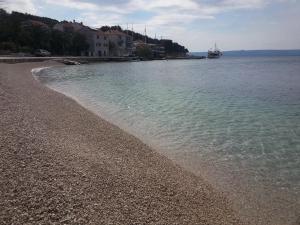 a beach with a rocky shore and the water at Apartment Tara in Sumartin