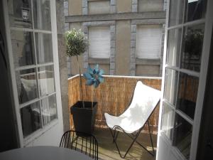 balkon z białym krzesłem i rośliną w obiekcie Le Saint-François w Saint-Malo