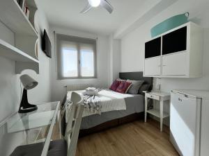 a small bedroom with a bed and a desk at Habitación Atocha Mendez in Madrid