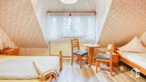 Un dormitorio con dos camas y una mesa y sillas. en De ole Spieker, en Munster im Heidekreis