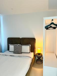 un letto con lenzuola e cuscini bianchi in una stanza di Phoenix garden a Mons
