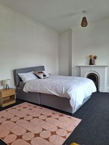 a bedroom with a large bed with a fireplace at Anfield Abbey House in Liverpool