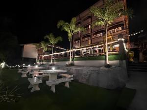 a row of tables and benches in front of a building at night at Chanmel Riverside in Chanthaburi