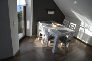 uma mesa branca e cadeiras num quarto com uma janela em Apartment unterhalb der Burg Hanstein em Bornhagen