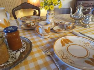 una mesa con platos y tazas sobre un mantel a cuadros en Villa Chorisia B&B, en Messina