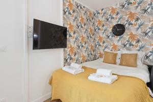 862 Suite Tulipe - Superb apartment في مونتروي: غرفة نوم عليها سرير وفوط
