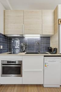 862 Suite Tulipe - Superb apartment في مونتروي: مطبخ مع الأجهزة البيضاء والبلاط الأزرق