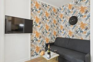 862 Suite Tulipe - Superb apartment في مونتروي: غرفة معيشة مع أريكة وطاولة مع كؤوس للنبيذ