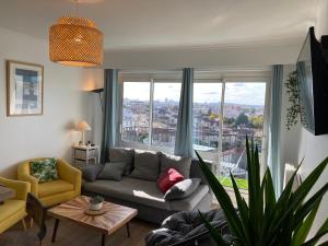 a living room with a couch and a large window at 3 chambres avec vue dégagée au calme proche Paris et aéroport - parking in Le Bourget