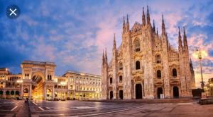 un grande edificio con torre dell'orologio di notte di Appartamento linea diretta Duomo a Milano