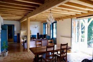 ein Esszimmer mit einem Holztisch und Stühlen in der Unterkunft Spacieuse maison de campagne/au cœur des vignobles in Chasselas