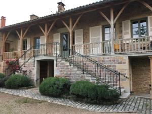 ein Backsteinhaus mit Balkon und eine Katze auf dem Dach in der Unterkunft Spacieuse maison de campagne/au cœur des vignobles in Chasselas