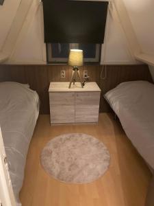 een slaapkamer met twee bedden en een tafel met een lamp bij Chalet 228 in Durbuy +53 foto's