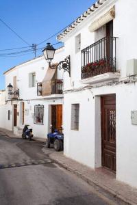 a white building with a scooter parked on a street at Casa Roberto Altea in Altea