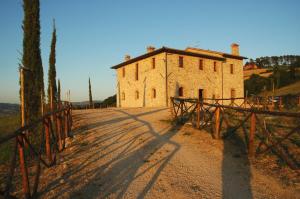 un viejo edificio con una valla delante en Agriturismo Fonte di Galiano en Monte Castello di Vibio