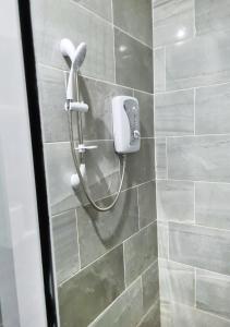 uma casa de banho com uma cabeça de chuveiro em Elegant Escape in Adenta- 2-Bed, 5star Service, Free Wifi, 24-7 Security, Close to Highway, by DLA 