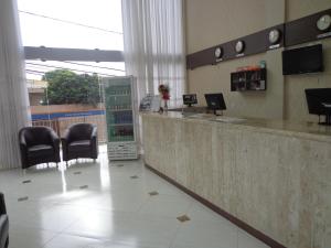 a waiting room with chairs and a counter in a store at Hotel Dom Baroni in Guarapuava