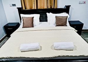 uma grande cama branca com duas toalhas em Elegant Escape in Adenta- 2-Bed, 5star Service, Free Wifi, 24-7 Security, Close to Highway, by DLA 