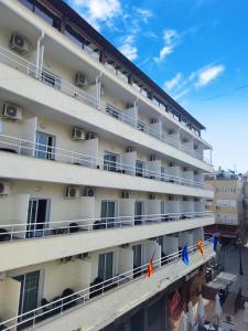 un grand bâtiment blanc avec drapeaux devant lui dans l'établissement Nch Hotel Torremolinos, à Torremolinos