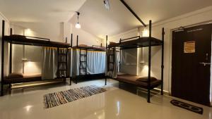 a room with several bunk beds with a rug at BunkNBrew in Palolem