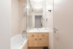 a bathroom with a tub and a sink and a shower at Appart'City Collection Paris Grande Bibliothèque in Paris