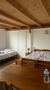 1 dormitorio con 2 camas y mesa de madera en Auberge Alsacienne, en Bussang