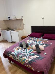 a bed with a purple comforter with towels on it at Hôtel Lyonnais in Nice