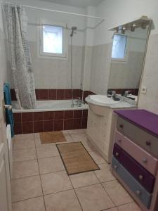 uma casa de banho com uma banheira, um lavatório e um espelho. em Joli appartement dans quartier calme de Perpignan em Perpignan