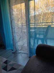 a room with a window with a chair and a table at Joli appartement dans quartier calme de Perpignan in Perpignan
