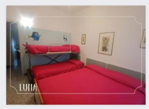 um quarto com 2 beliches e lençóis vermelhos em Guest House Attico Della Vittoria em Gabicce Mare