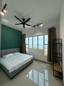 een slaapkamer met een bed en een plafondventilator bij Amber Cove Seaview I MUJI 2BR I Game Room I 3-9pax in Melaka