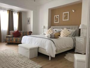 ein weißes Schlafzimmer mit einem großen Bett und einem Sofa in der Unterkunft SUBLIME APPARTEMENT in Provins
