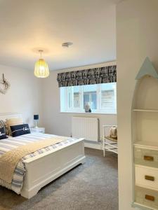 Un dormitorio con una cama grande y una ventana en Contemporary Holiday apartment, en Perranporth