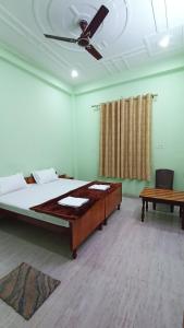 1 dormitorio con 1 cama y ventilador de techo en ARJUN PAYING GUEST HOUSE en Ayodhya