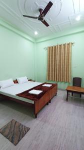 1 dormitorio con 1 cama y ventilador de techo en ARJUN PAYING GUEST HOUSE en Ayodhya