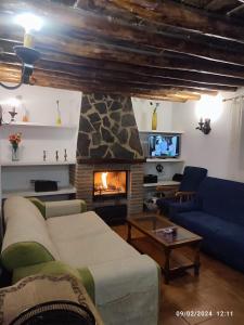 Pinos PuenteにあるCasa Rural Huerta Sarténのソファと暖炉のあるリビングルーム