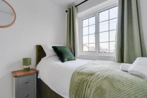 Schlafzimmer mit einem Bett und einem Fenster in der Unterkunft Leyland House - Private Parking Free Wi-Fi Garden in Leyland