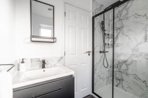 a white bathroom with a sink and a shower at Leyland House - Private Parking Free Wi-Fi Garden in Leyland